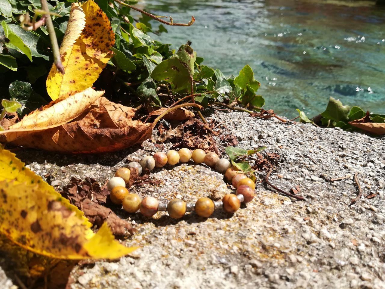 Bracciale artigianale in pietre naturali, foto nella natura con fiume che scorre.