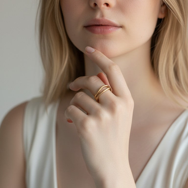 Anello Heartbeat Kiss di DSCREAZIONI in bronzo con design a due linee curve indossato su una mano femminile