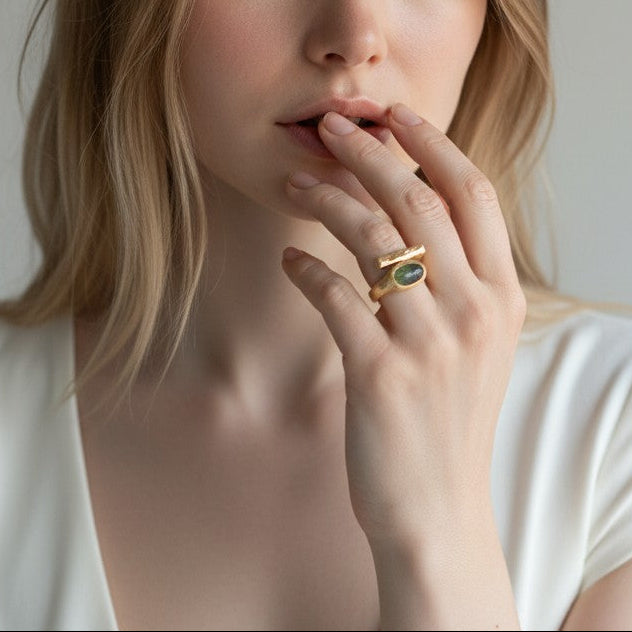 Anello DSCREAZIONI Frammento Smeraldo in bronzo dorato 18k con pietra ovale sfaccettata indossato su una mano